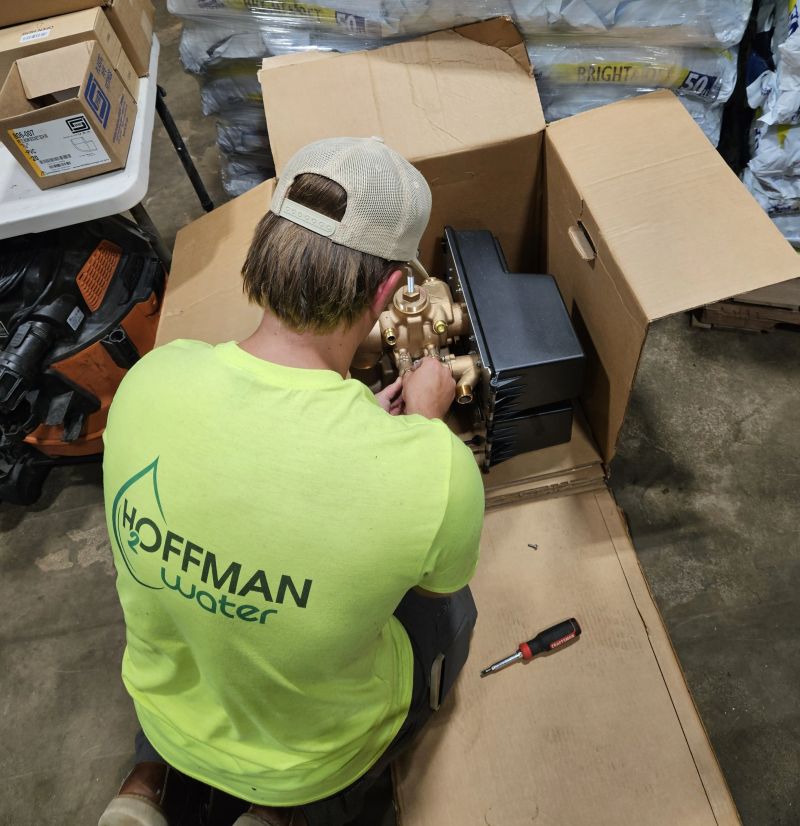 A Hoffman Soft Water technician servicing a Fleck 3900 control valve injector in the shop
